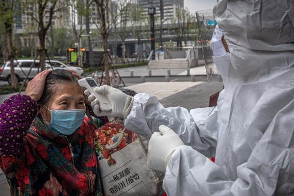 Toman temperatura con termómetros infrarrojo en China para monitorear el COVID-19