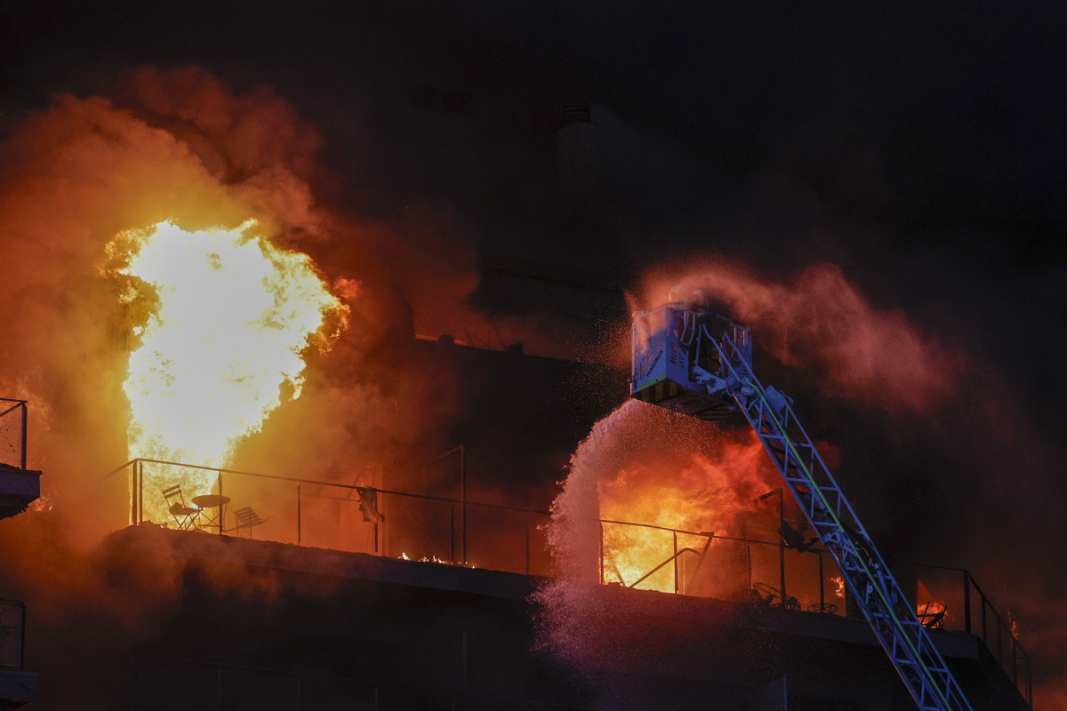 Los bomberos intentan rescatar a vecinos atrapados por el fuego desde los balcones