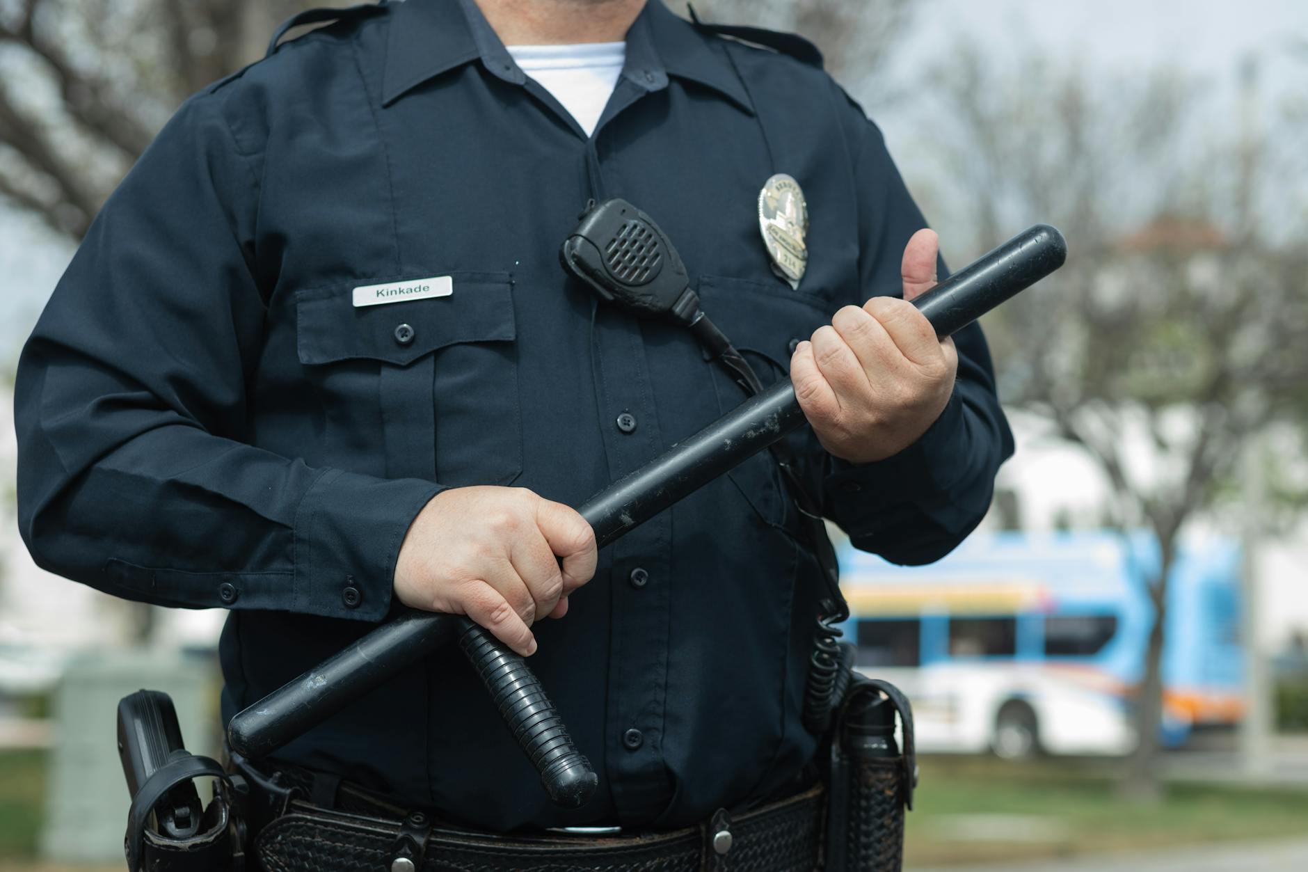 man in black police uniform holding a baton